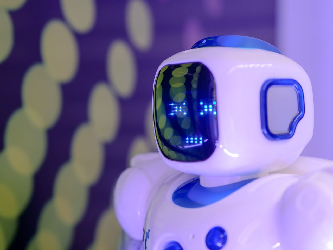 services-04 Close-up of a futuristic humanoid robot with a luminescent display in a modern setting.